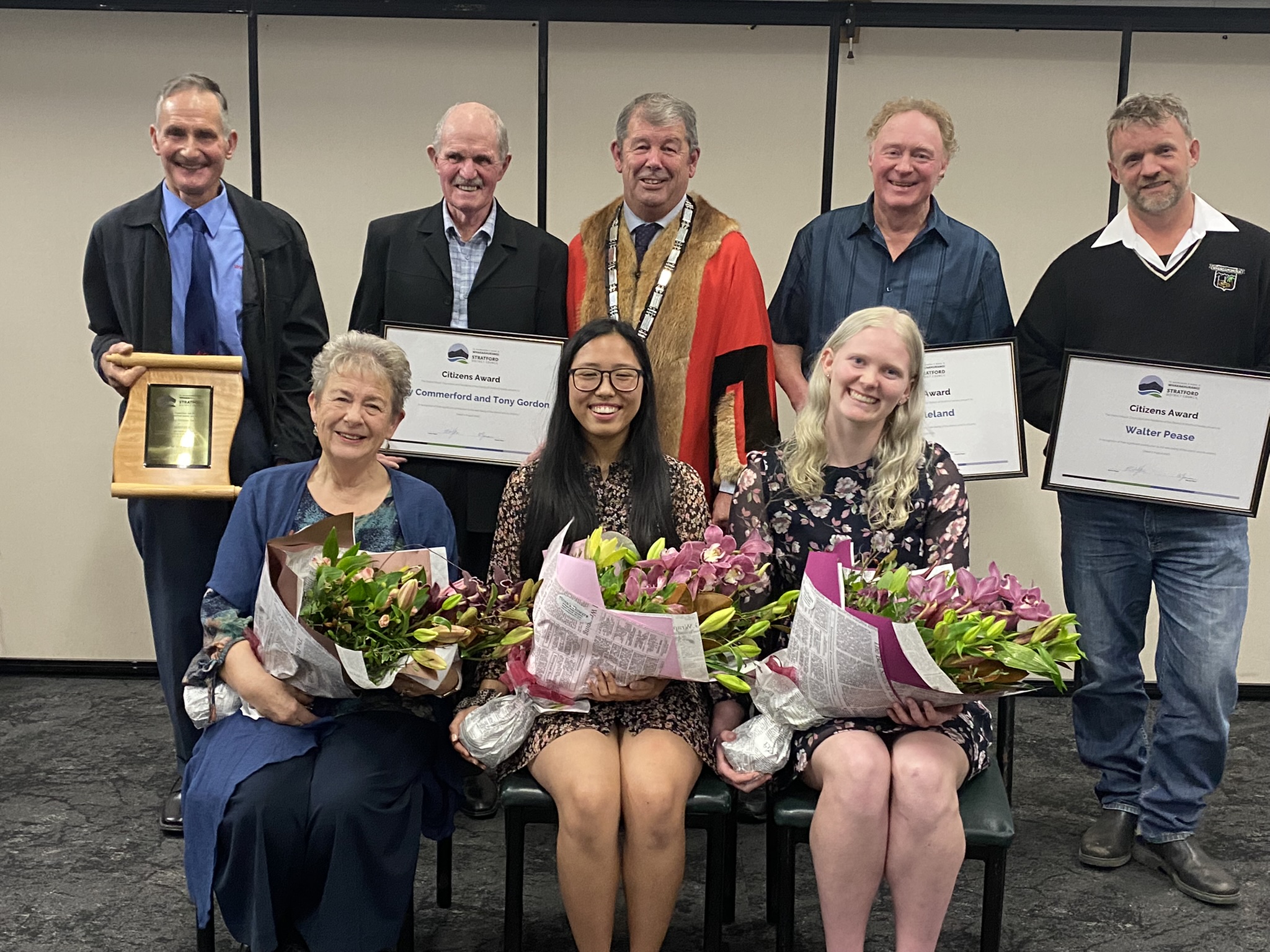 Photo of the 2022 Citizen Award recipients with Mayor Neil Volzke. The recipients are holding their flowers and certificates. 